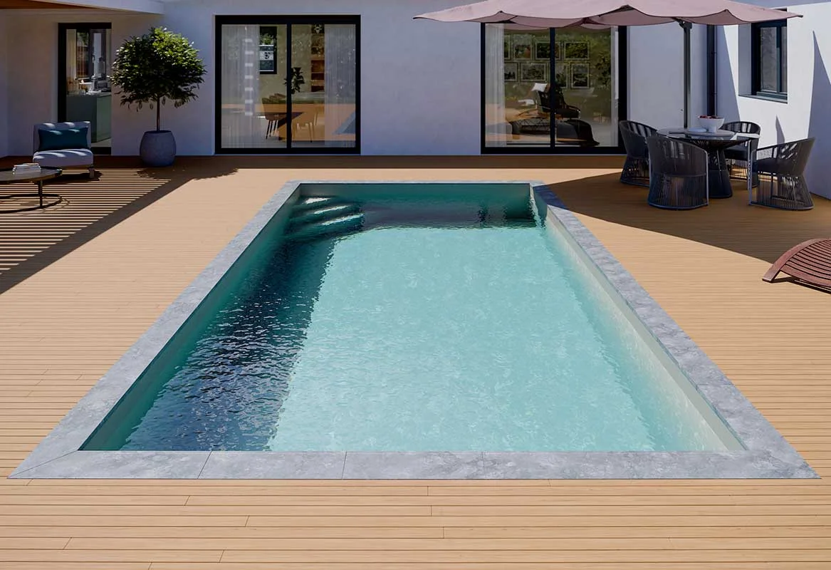 Piscine Quickly rectangulaire terminée, bordée d'une terrasse avec transats et parasol